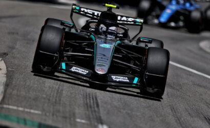 Mercedes-AMG Petronas Formula 1 car speeding around a track, front view in black and teal livery with sponsor logos visible