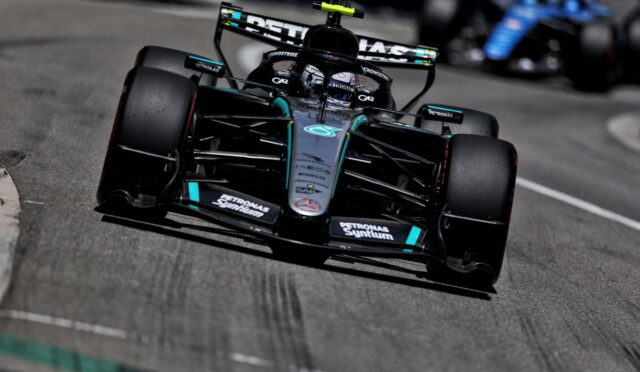 Mercedes-AMG Petronas Formula 1 car speeding around a track, front view in black and teal livery with sponsor logos visible