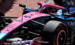 Pink Formula 1 race car with blue accents, number 11 and BWT logos, on a track.