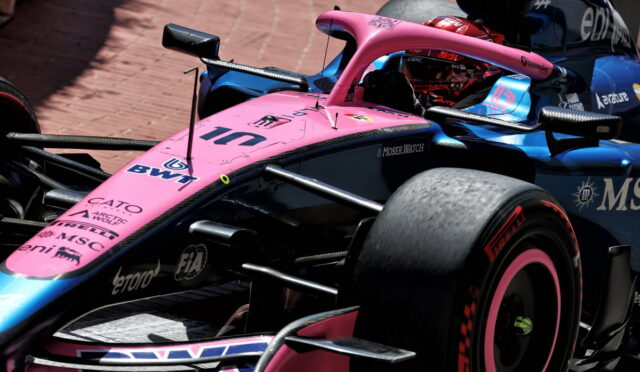 Pink Formula 1 race car with blue accents, number 11 and BWT logos, on a track.
