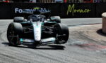 Mercedes F1 car from Mercedes-AMG Petronas speeds through a Monaco street circuit with barriers and spectators in the background