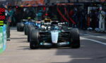 Mercedes F1 car in the pit lane, front wing low, preparing for a race start or pit stop.
