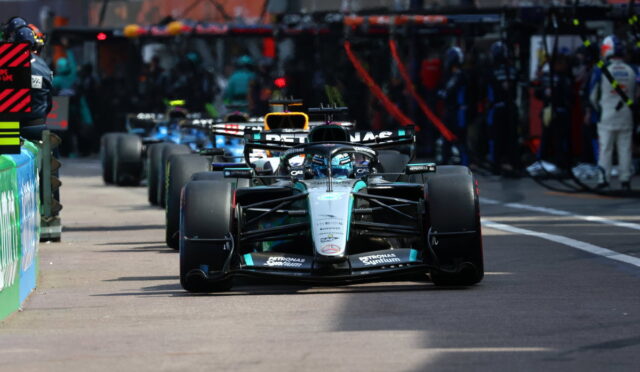 Mercedes F1 car in the pit lane, front wing low, preparing for a race start or pit stop.