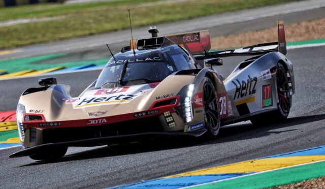 Beige Hertz Cadillac DPi race car navigating a curve on a track with colorful curbs.