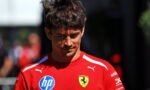 Young man in a red Ferrari team shirt looking down, with HP and Ferrari crest logos visible.