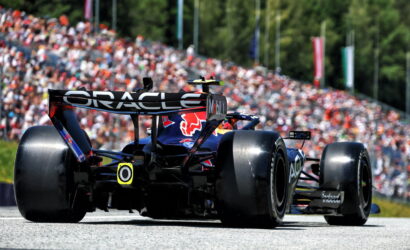 Rear view of a Formula 1 car on a race track with Oracle branding and a packed grandstand in the background.