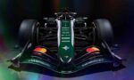 Front view of a dark green Formula 1 race car with sponsor logos and rainbow reflections in a studio setting.