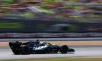 Mercedes-AMG Petronas Formula One car speeding on the track with blurred grandstands in the background, sponsor logos visible below.