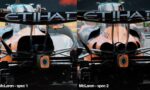 Two McLaren Formula 1 cars facing the camera from the front, orange-and-silver livery with sponsor logos across the nose.