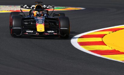 Formula 1 car from Red Bull Racing speeds around a colorful race track curbstone.