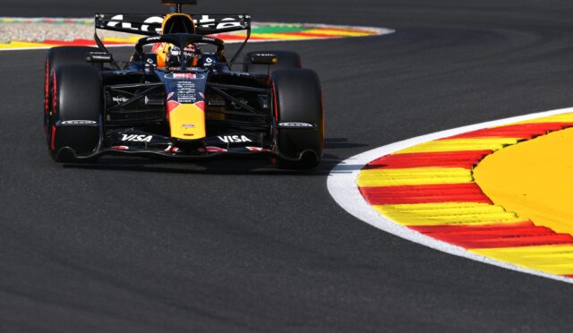 Formula 1 car from Red Bull Racing speeds around a colorful race track curbstone.