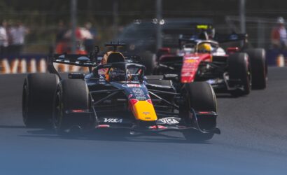 Front and center Red Bull Racing Formula 1 car on track, with two competing cars behind in a race.