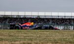 Formula 1 Red Bull Racing car on a race track with packed grandstands in the background.