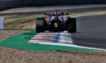 Rear view of a Formula 1 race car on a track, Oracle branding on the rear wing and a striped curb in front.