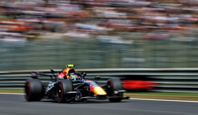 Red Bull Racing Formula 1 car speeding around a bend on a race track with blurred grandstands in the background.