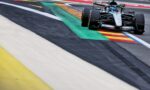 Mercedes-AMG F1 car cornering on a race track with colorful curbs nearby