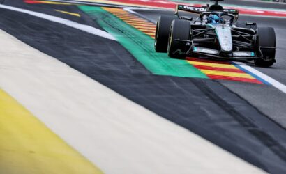 Mercedes-AMG F1 car cornering on a race track with colorful curbs nearby
