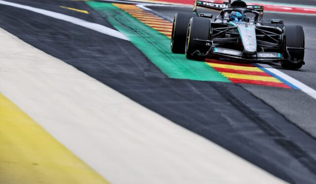 Mercedes-AMG F1 car cornering on a race track with colorful curbs nearby