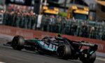Formula 1 race car labeled Petronas and Microsoft speeding along a race track with a blurred crowd in the background.
