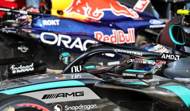 Close-up of race cars side-by-side in a pit area, with prominent Red Bull, Oracle, and Snapdragon branding on the hulls.