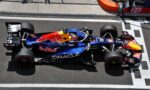 Top-down view of a Red Bull Racing Formula 1 car on the pit lane, blue livery with Red Bull logo and sponsor decals like Oracle and Visa.