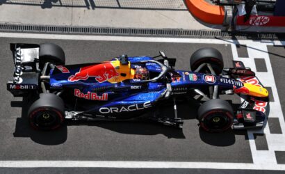 Top-down view of a Red Bull Racing Formula 1 car on the pit lane, blue livery with Red Bull logo and sponsor decals like Oracle and Visa.