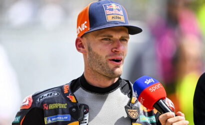 Moto racer wearing a KTM/Red Bull cap speaks into a blue Sky Sport microphone during an interview after a race.