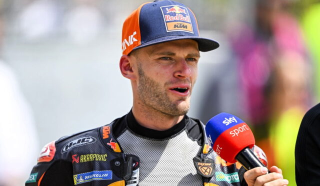 Moto racer wearing a KTM/Red Bull cap speaks into a blue Sky Sport microphone during an interview after a race.