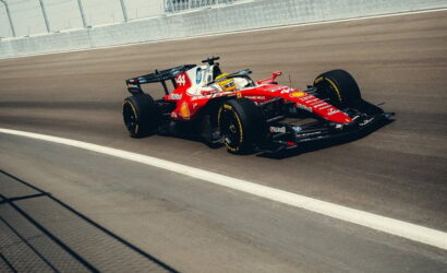 Red Formula 1 race car on a racing track, speeding along near the wall barrier.