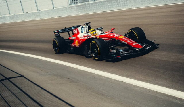Red Formula 1 race car on a racing track, speeding along near the wall barrier.