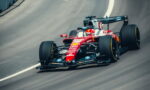 Red Ferrari Formula 1 car racing on a curved track, number 16 visible
