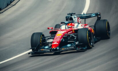 Red Ferrari Formula 1 car racing on a curved track, number 16 visible