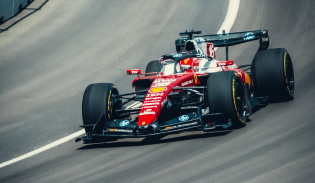 Red Ferrari Formula 1 car racing on a curved track, number 16 visible