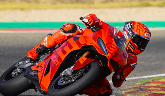 Racer in bright orange suit motorcycle racing into a sharp turn on an orange sport bike.