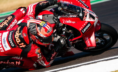 MotoGP rider in red Ducati livery leaning into a corner on track