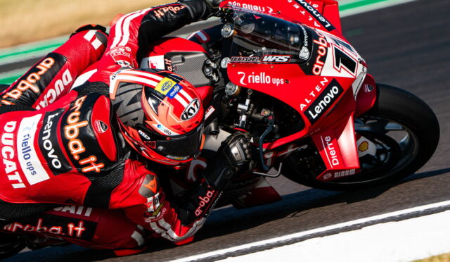MotoGP rider in red Ducati livery leaning into a corner on track