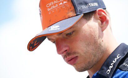Close-up of a man in an orange and navy cap with Oracle Red Bull Racing and Alphatauri logos visible on the hat.