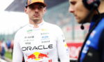 Formula 1 driver in an Oracle Red Bull Racing suit and orange cap on the pit lane, looking toward the camera.