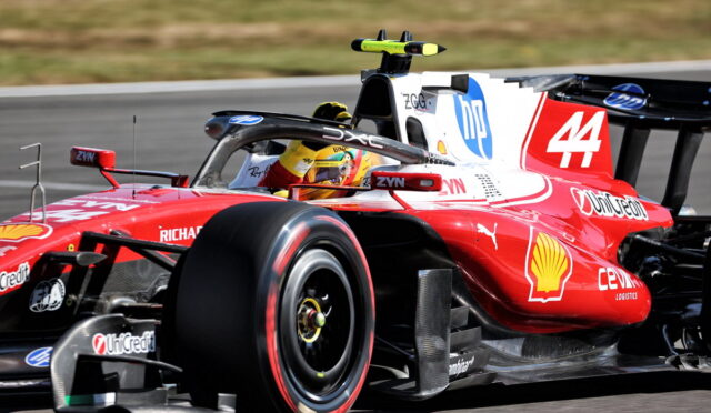 Red Formula 1 race car on a track with driver in yellow helmet, number 44 and Shell logo visible on the side