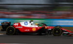 Red Formula 1 car with number 44 speeding on track, sponsor logos visible, motion blur emphasizes high speed.