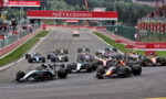 Front row of Formula 1 cars at the start of a race on a track lined with Moët & Chandon banners.