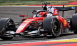 Red Ferrari Formula 1 car on a race track, close-up view showing sponsor logos and number 16 on the sidepod.