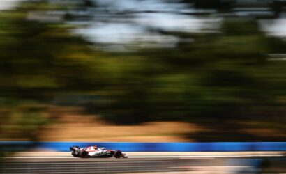 Formula 1 car speeding along a race track with motion blur in the background to convey high speed and motion.