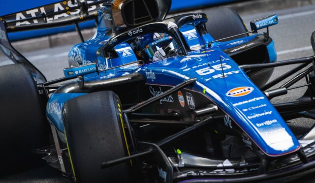 Blue Williams Formula 1 car cockpit up close with front wing and sponsor logos like Barclays visible.