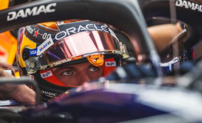 Close-up of a racing helmet inside a cockpit, with Oracle branding and sponsor logos visible (Visa, Mobil)