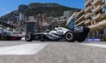 Formula 1 car on a street circuit with city buildings and a mountain backdrop in clear blue sky.