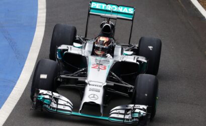 Top-down view of a Mercedes Petronas Formula 1 car on the track, front angled toward the camera with number 23 on the nose.