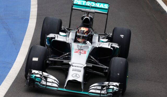Top-down view of a Mercedes Petronas Formula 1 car on the track, front angled toward the camera with number 23 on the nose.