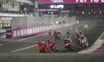 Motorcycle race on a curving track with riders leaning into a turn; Qatar Airways banners overhead.