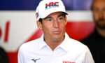 Man wearing a white Honda Racing cap and polo shirt at a press event.
